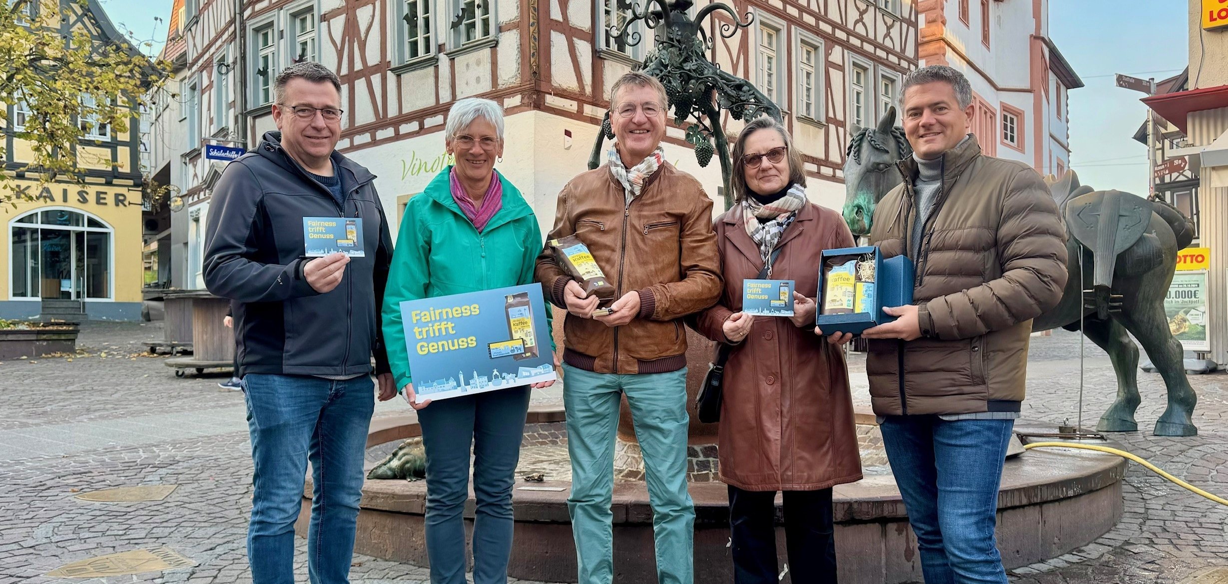 Mehrere Personen mit Schokoladentafeln vor dem Alzeyerr Roßmarktbrunnen