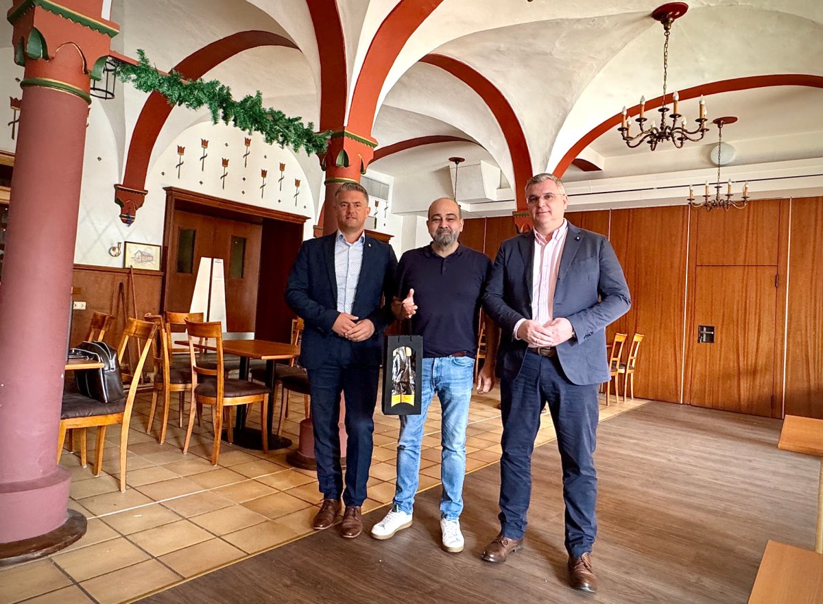 3 Männer und einem mit einem Geschenk der Stadt Alzey