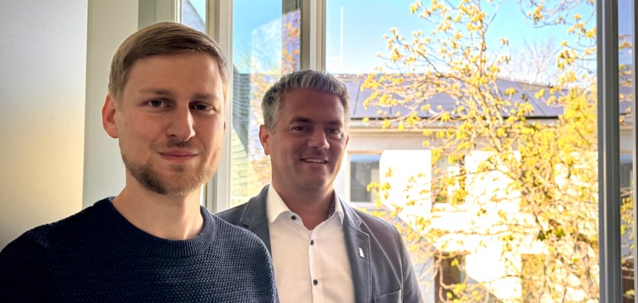 2 Männer am offenem Fenster mit strahlender Sonne