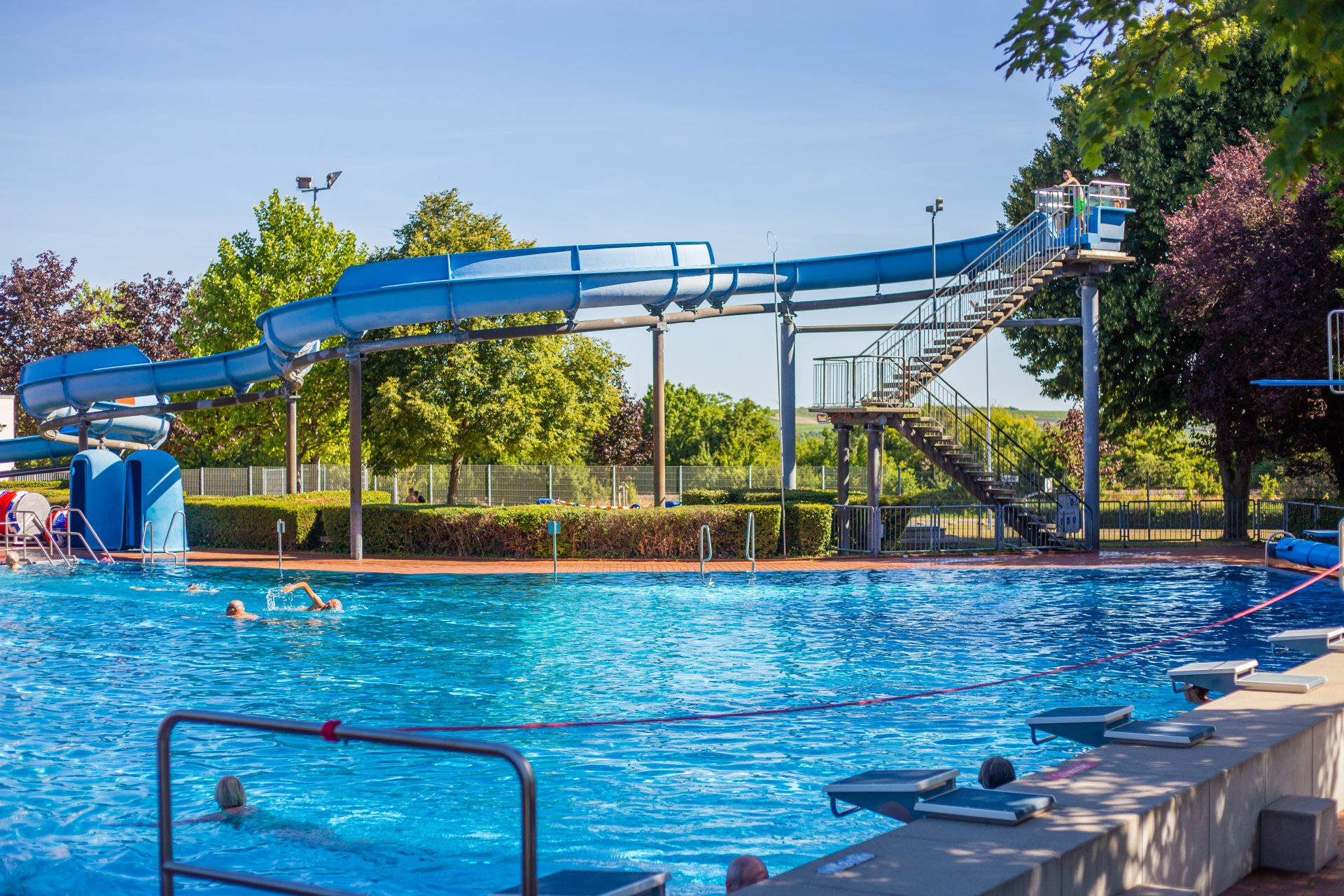blaue Rutsche des Wartbergbades mit schwimmenden Gästen im Wasser
