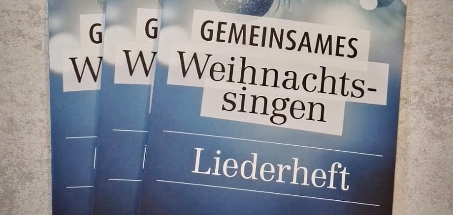 3 Liederhefte "Gemeinsames Weihnachtssingen" liegen auf einem Tisch.