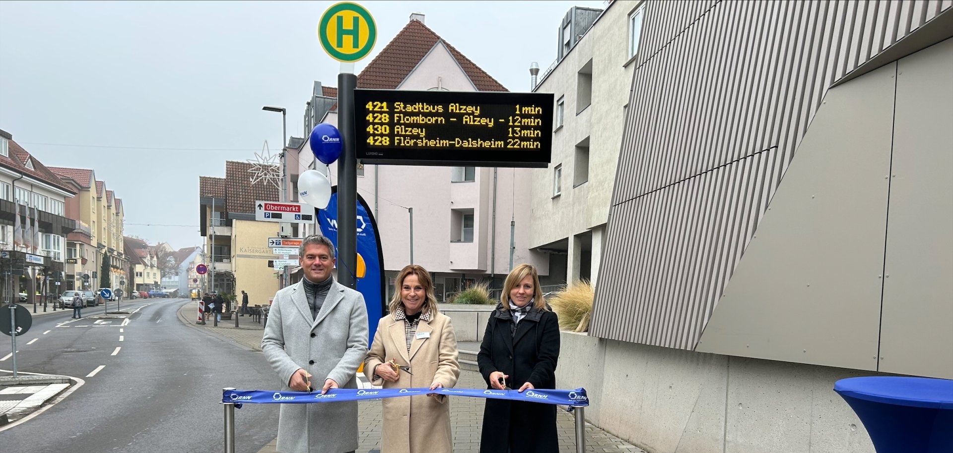 Digitalisierung im Busverkehr DFI-Anzeiger am Museumsplatz in Alzey in Betrieb genommen / Einweihung des DFI-Anzeigers mit Bürgermeister Steffen Jung, Silke Meyer und Stephanie Jung