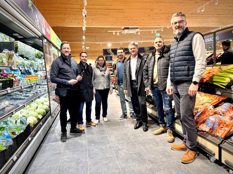 Holz Aldi feiert Wiedereröffnung, Vorzeigemarkt setzt neue Massstäbe in Alzey. (Zusehen ist Bürgermeister Steffen Jung mit der Marktleitung und anderen Beteiligten im Markt)