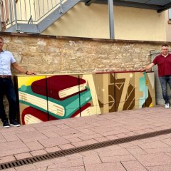 Neu gestaltete Stromkästen (Bunte Bücher und der schriftzug Alzey auf den Stromkästen), Bürgermeister Steffen Jung und Markus Krebs vom Stadtmarketing sind zu sehen.