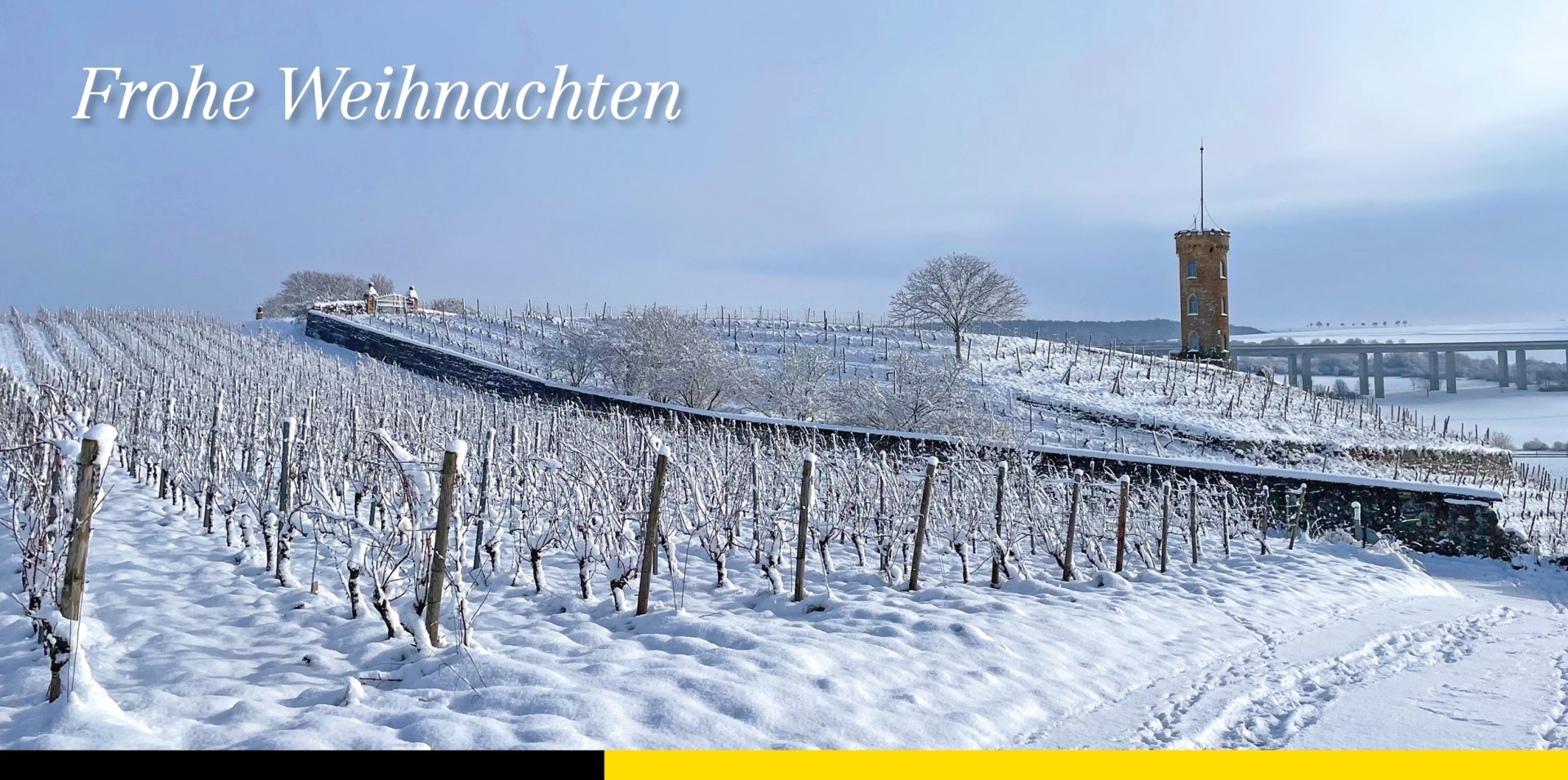 Links Oben im Bild steht Frohe Weihnachten und darunter ist eine verschneite Landschaft der Weinberge zu sehen.