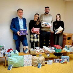 Wunschbaumaktion des Rheinhessen Centers "113 Kinderwünsche" Alzeyer Kita erfüllten Kinder Wünsche. (Zu sehen sind viele verpackte Geschenke Bürgermeister Steffen Jung und die Verantwortlichen für diese Aktion)