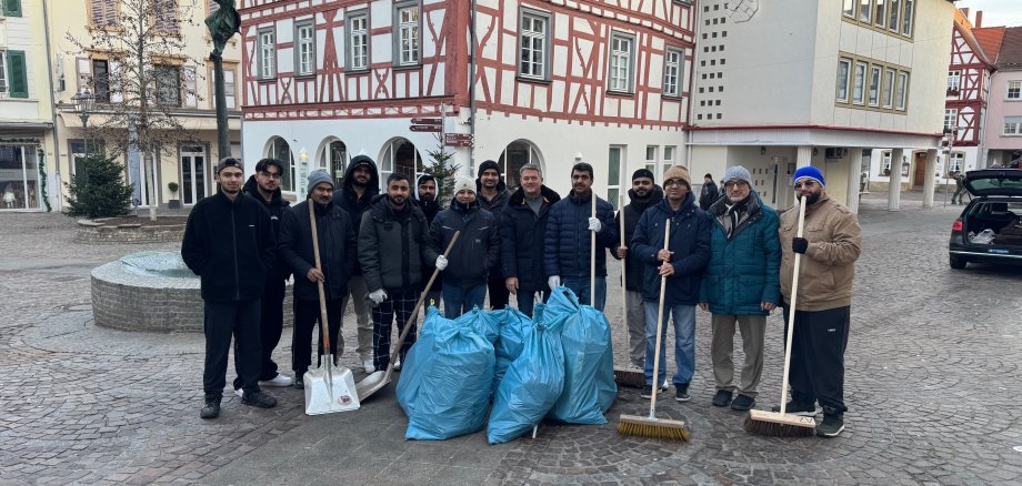 Rund 20 Männer stehen mit Bürgermeister Jung hinter dem gesammelten Müll des Neujahrsmorgens.
