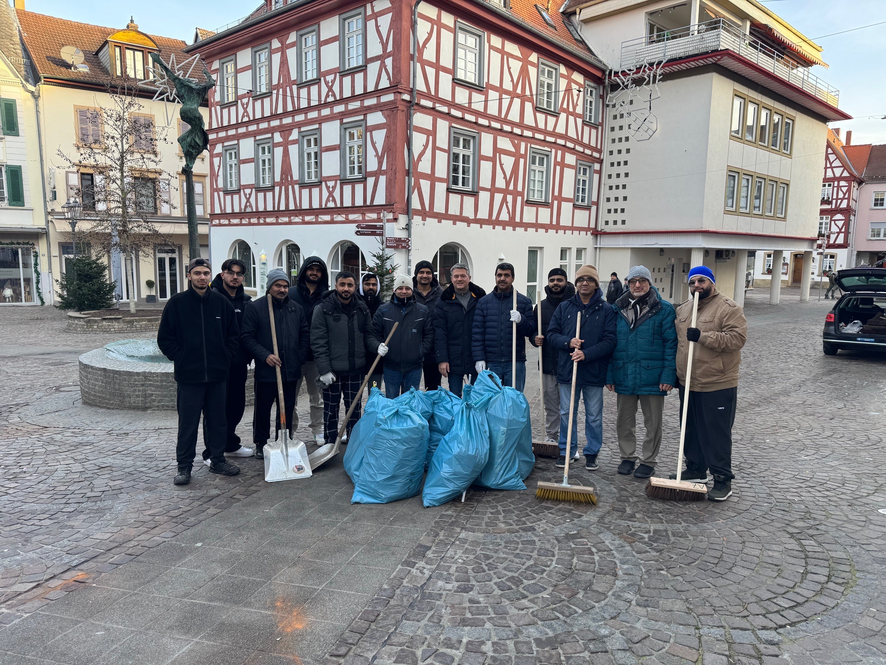 Rund 20 Männer stehen mit Bürgermeister Jung hinter dem gesammelten Müll des Neujahrsmorgens.