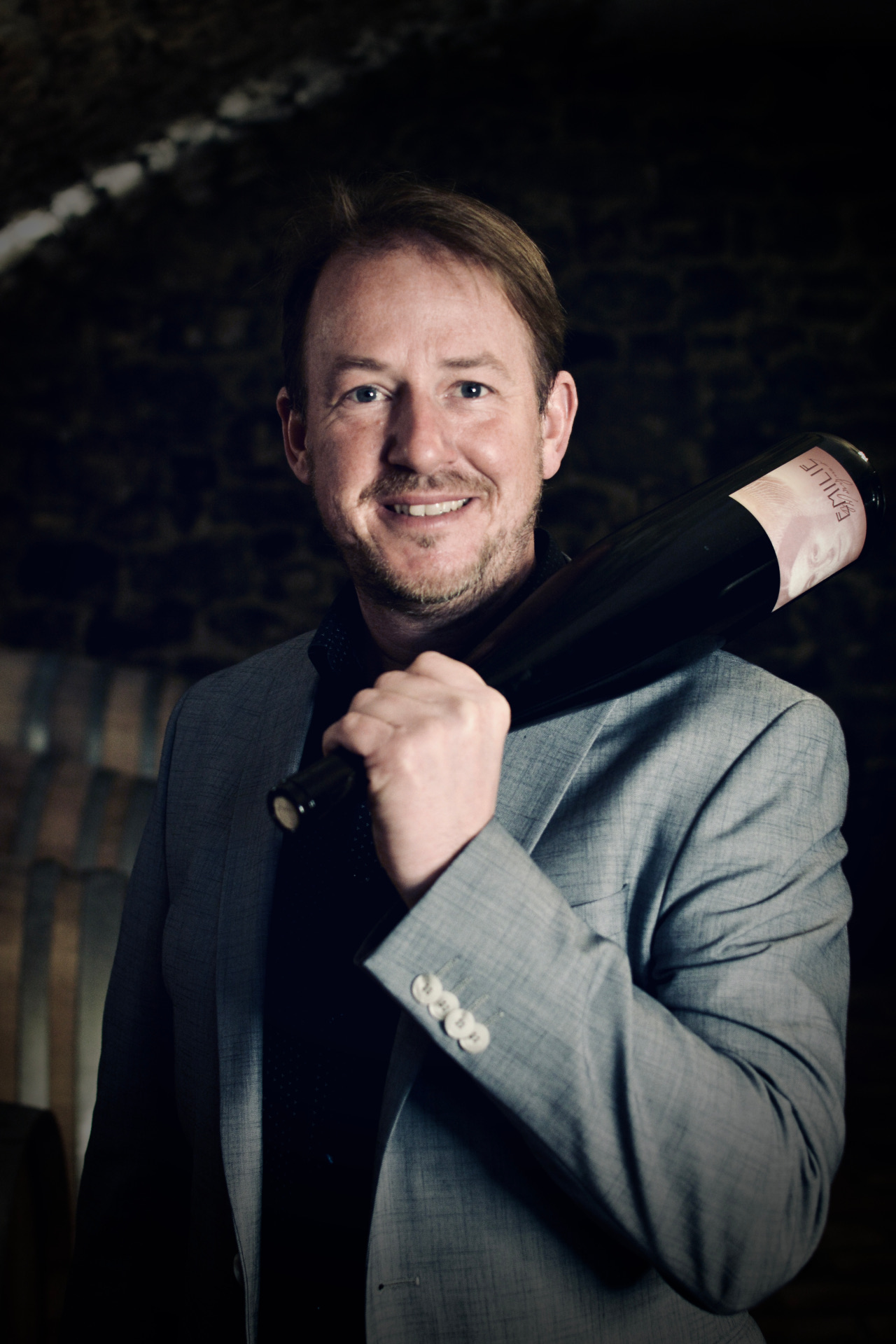 Andreas Wagner mit einer Weinflasche auf der Schulter