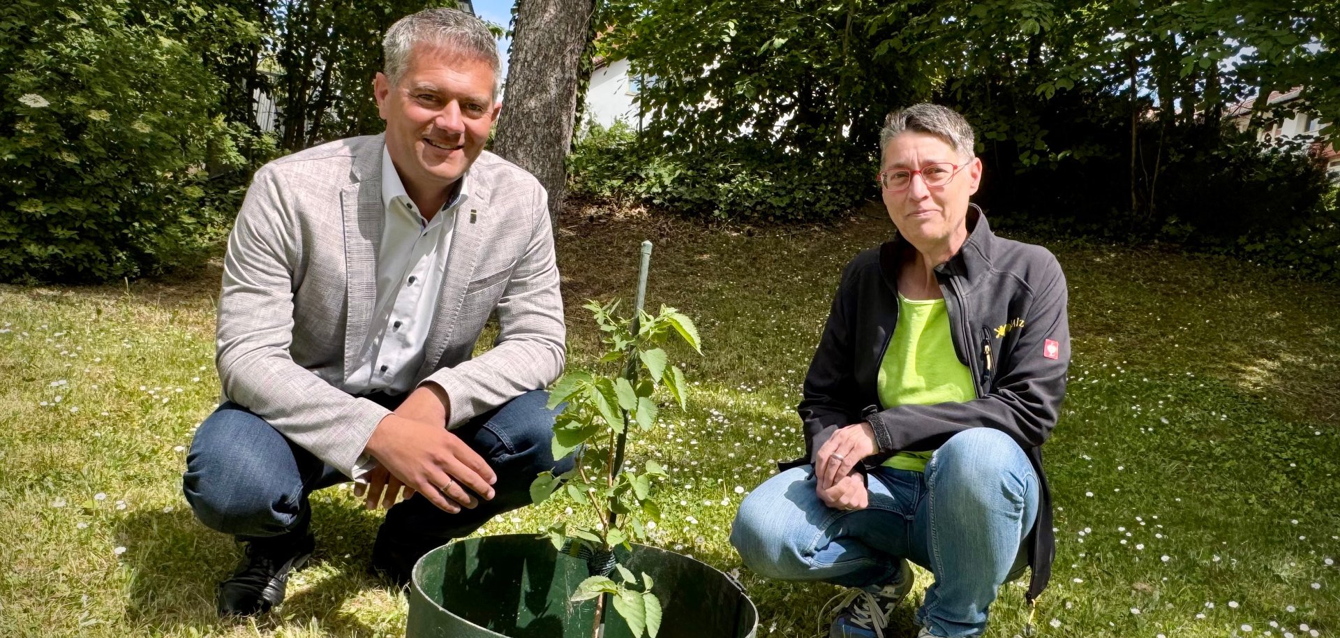 2 Personen mit einem Mini Baum in der Mitte