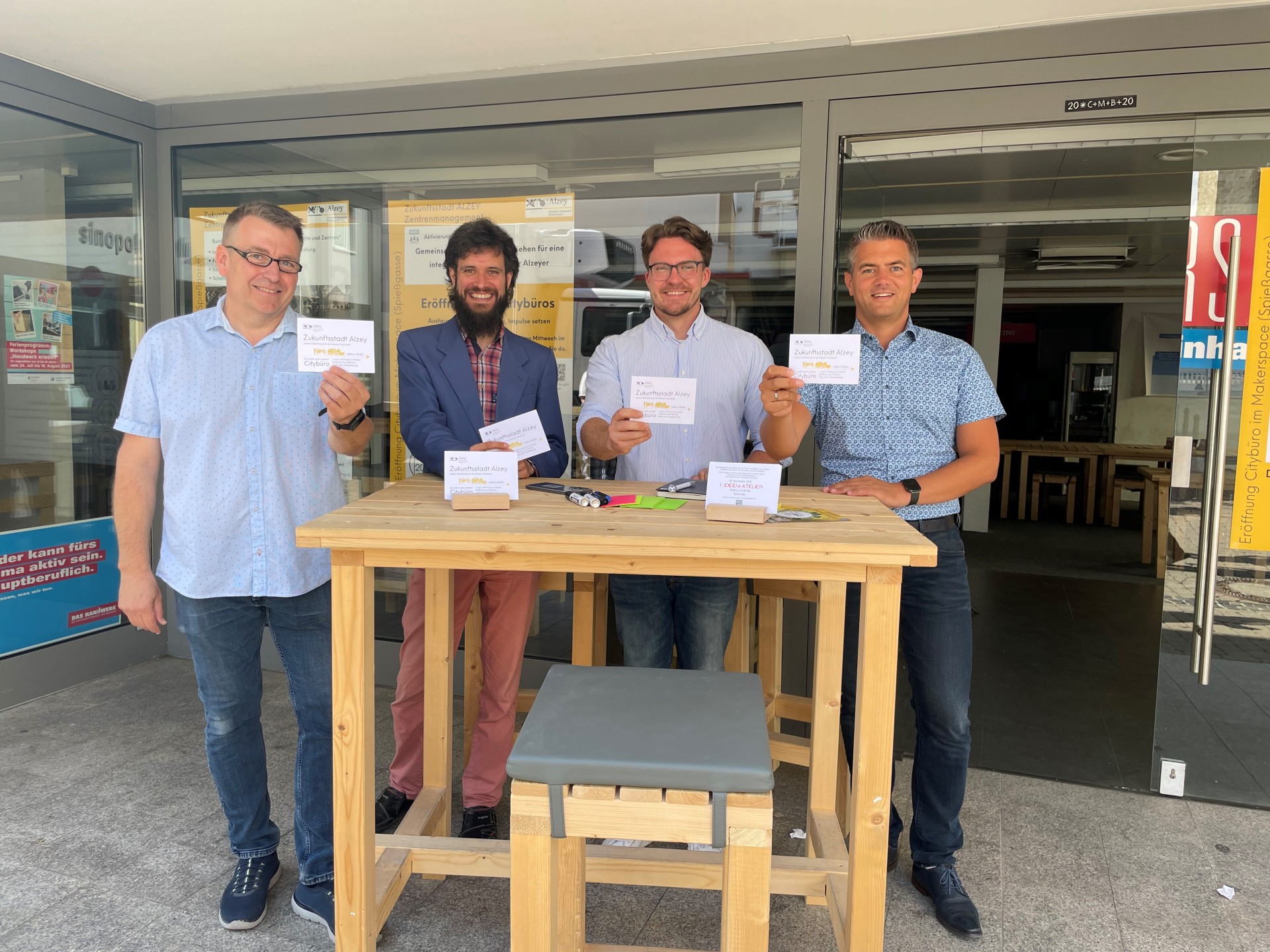 4 Männer mit einer Karte in der Hand mit der Schrift "Zukunftsstadt Alzey"
