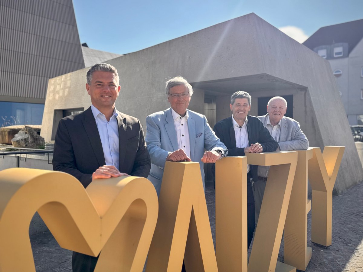 4 Männer stehen an einem goldenen Schriftzug "Herz" Alzey