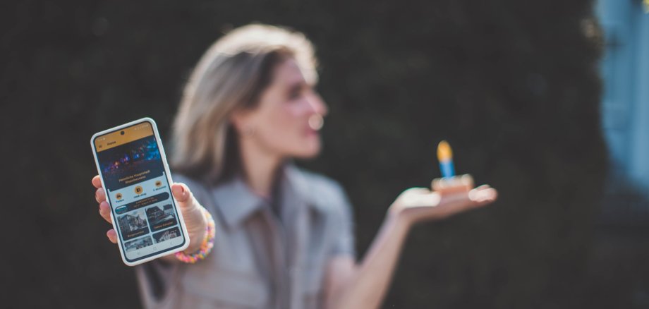 r Homepage der Stadt Alzey App und ein Kuchenstück mit einer Kerze