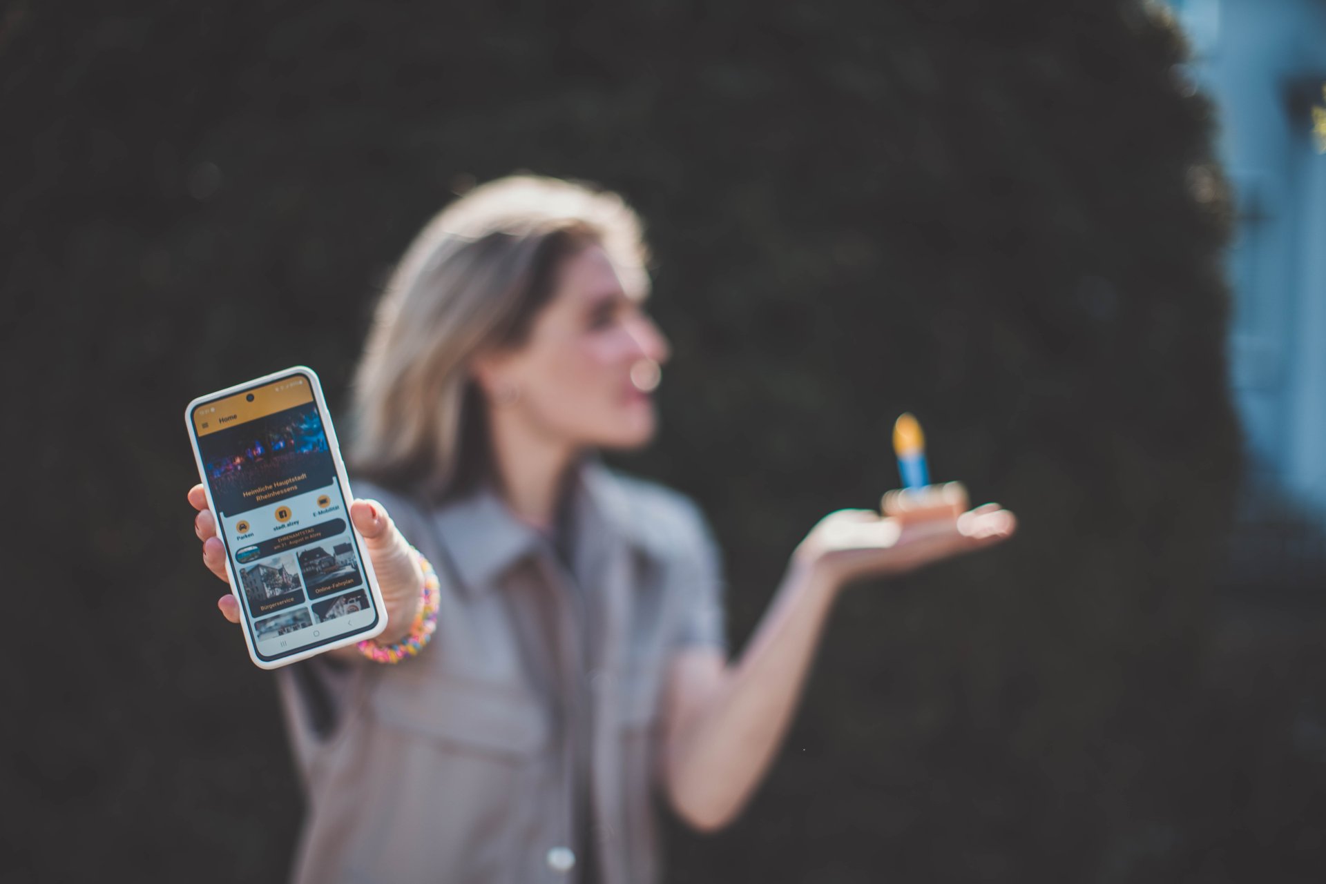 r Homepage der Stadt Alzey App und ein Kuchenstück mit einer Kerze