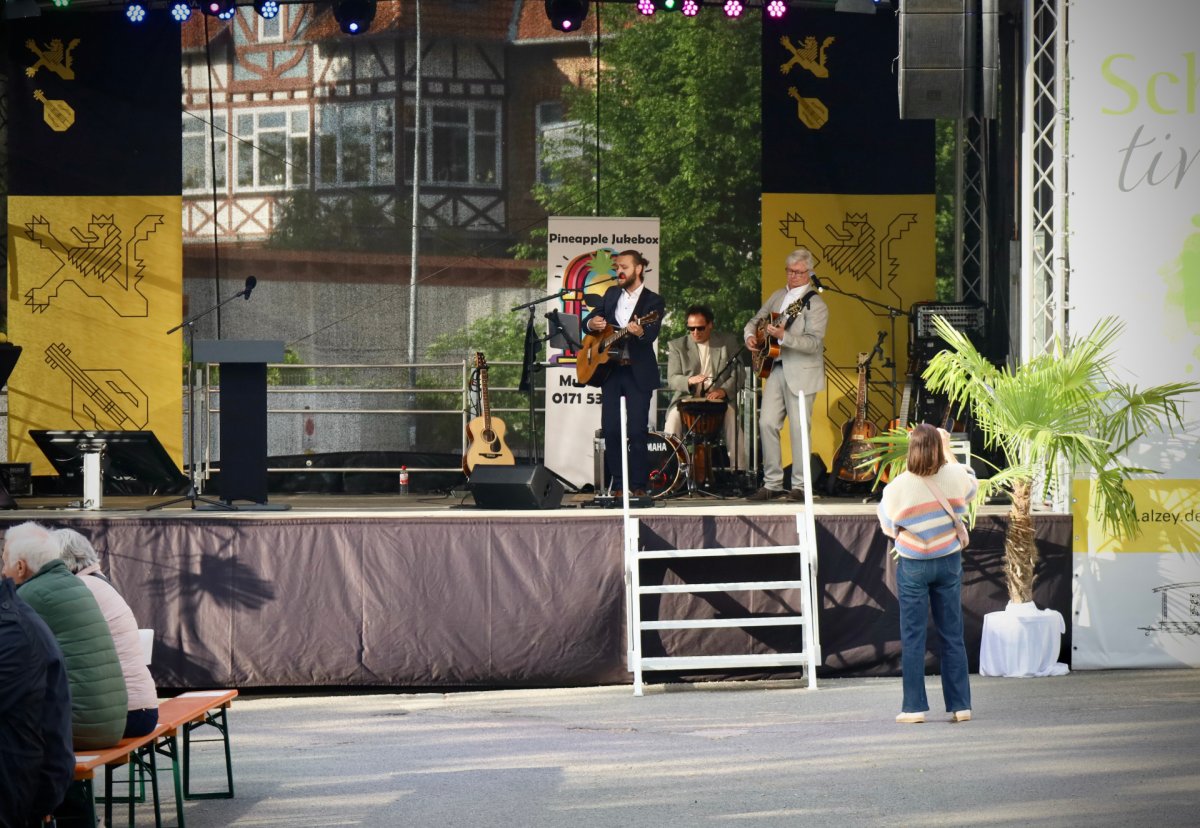 3 Personen mit Instrumenten und einer singt