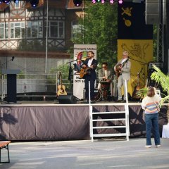 3 Personen mit Instrumenten und einer singt