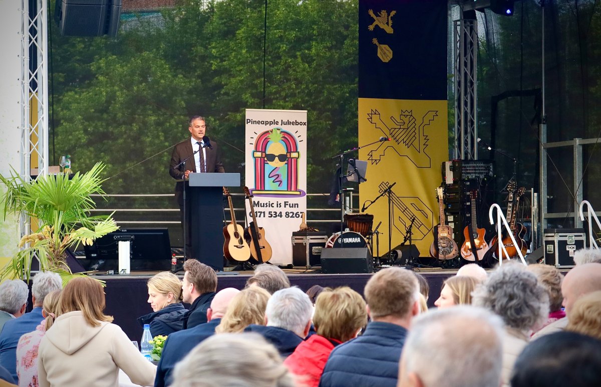 Der Bürgermeister hält auf der Bühne eine Rede