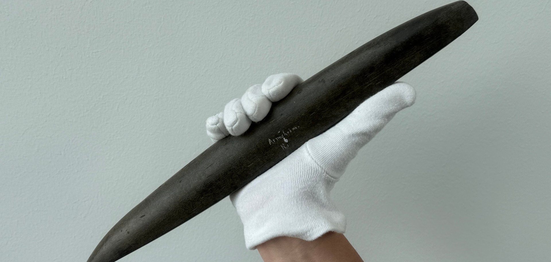 ein weißer Handschuh angezogen und in der Hand ein etwas spitzer Gegenstand mit Armsheim eingraviert