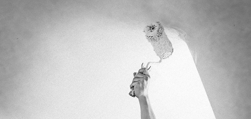 Ein  Maler streicht eine Wand