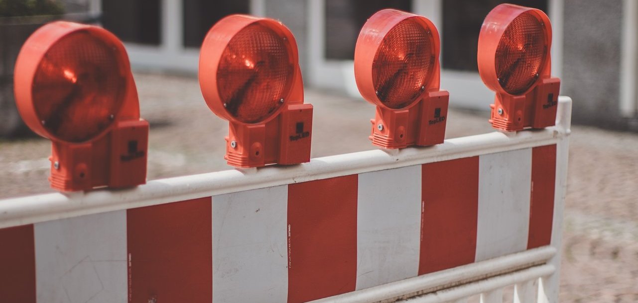 Auf dem Bild ist eine Verkehrsabsperrung in den farben rot und weiß aufgestellt.