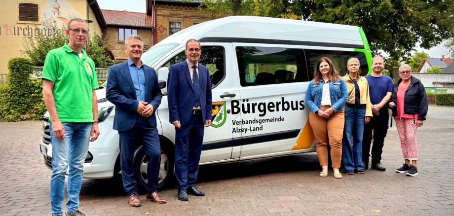 Der Bürgermeister Steffen Jung und Bürgermeister der Verbandsgemeinde Alzey -Land stehen mit weiteren fünf Personen vor dem Bürgerbus.