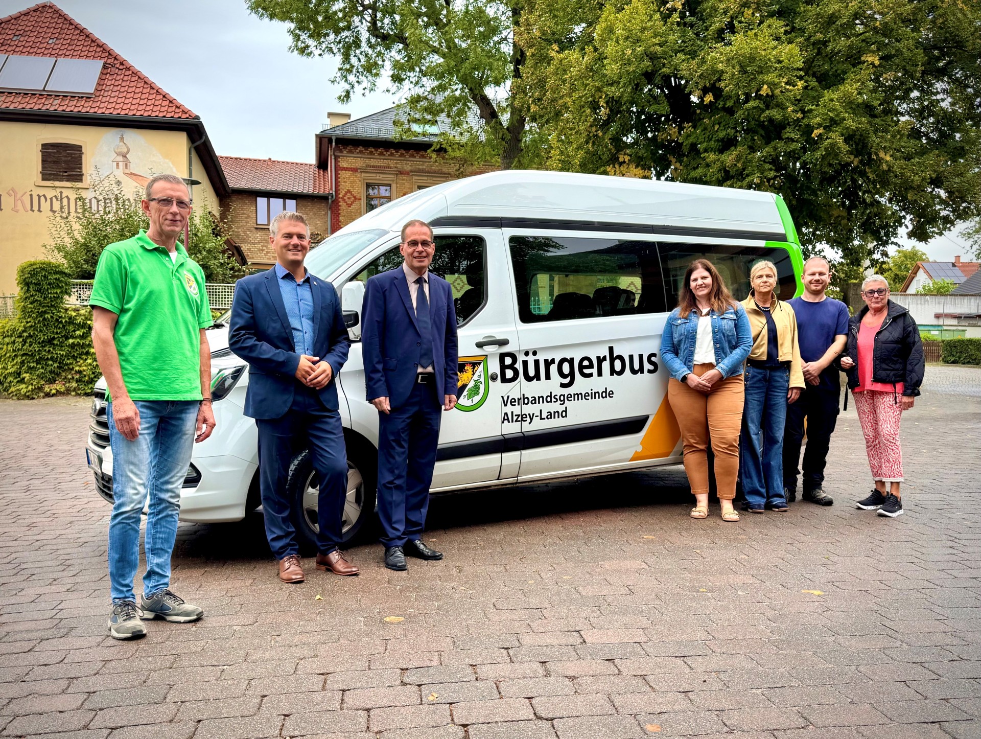 Der Bürgermeister Steffen Jung und Bürgermeister der Verbandsgemeinde Alzey -Land stehen mit weiteren fünf Personen vor dem Bürgerbus.