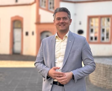 Bürgermeister Steffen Jung im grauen Anzug auf dem Fischmarkt in Alzey