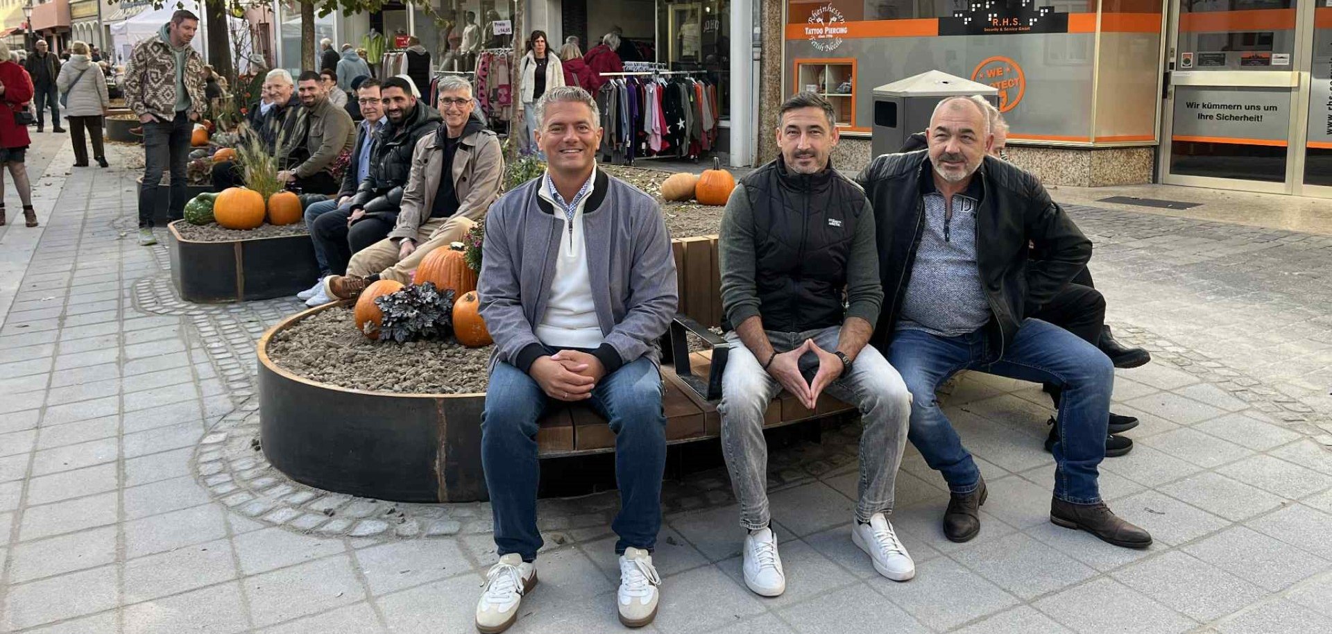 Mehrere personen, darunter Bürgermeister Steffen Jung sitzend auf den neuen Bänken in der Spießgasse.