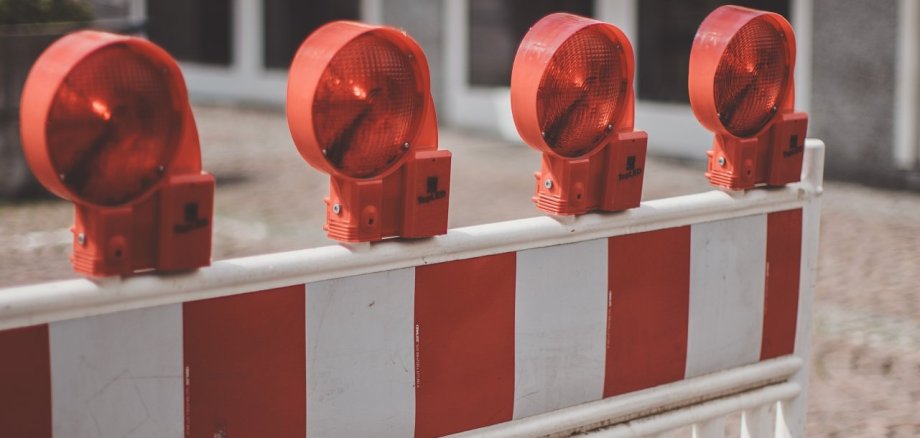 Auf dem Bild ist eine Verkehrsabsperrung in den farben rot und weiß aufgestellt.