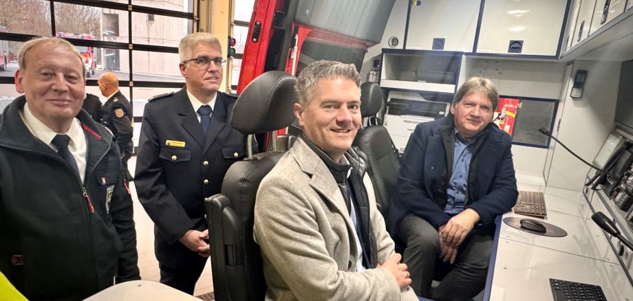 Man sieht einige Menschen der Freiwillige Feuerwehr Alzey die in Ihrem neuen Einsatzleitwagen sitzen und in die Kamera schauen.