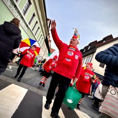 Fastnachtsumzug verkleidete Menschen die eine Staße entlang gehen