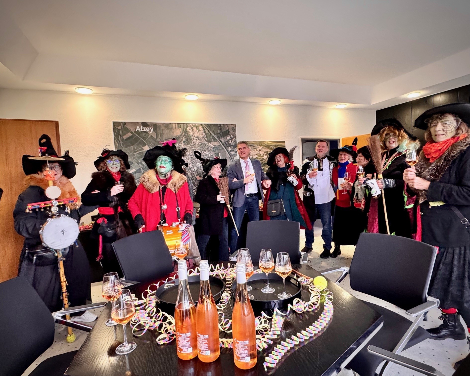 Die Alser Hexen im Rathaus neben Bürgermeister Steffen Jung, festlich verzierter Tisch mit Sekt und Luftschlangen