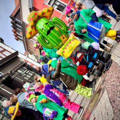 Kinderfastnachtsumzug verkleidete Kinder die eine Straße entlanag laufen