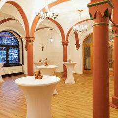 Ein heller Raum in der Stadthalle mit einigen Stehtischen.