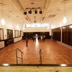 Ein Bild von der Bühne der Stadthalle aus in den Saal. Da stehen einige wenige Menschen.