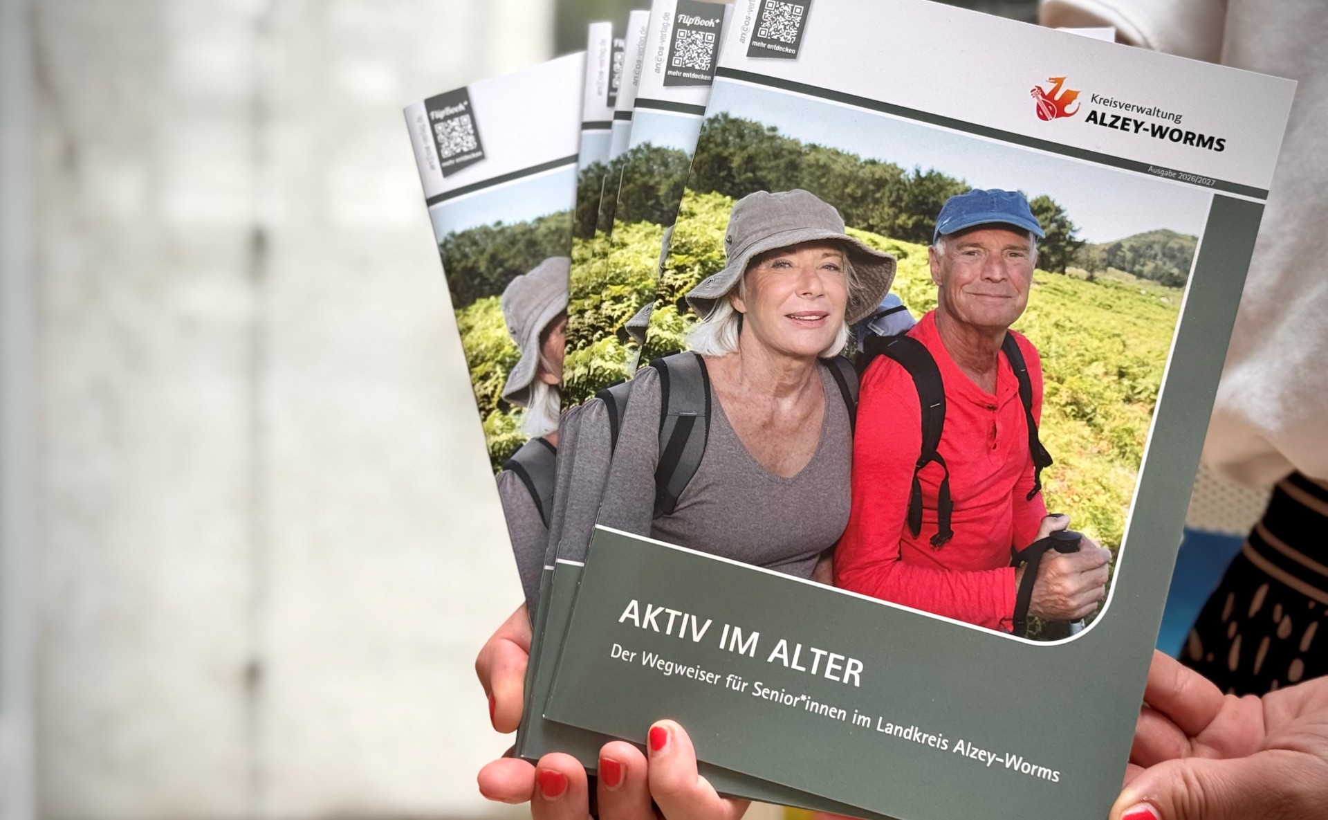 zwei ältere Personen im Wander-Outfit sind auf dem Cover eines Prospekts zu sehen, beide schauen glücklich in die Kamera
