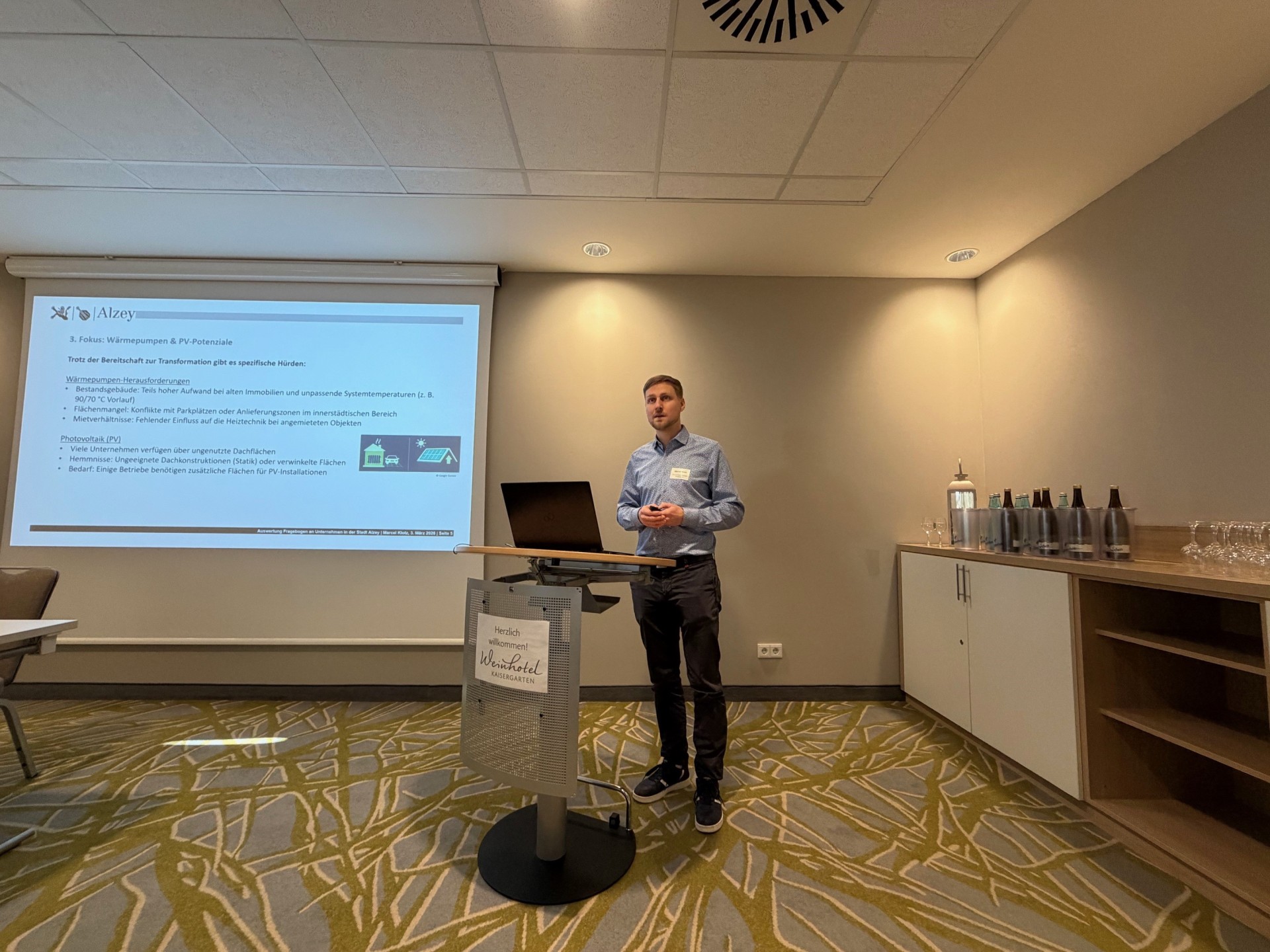 Man sieht jemanden vom Weinhotelkaisergarten, der eine Präsentation zum Thema: "Wermepumpen" hält.
