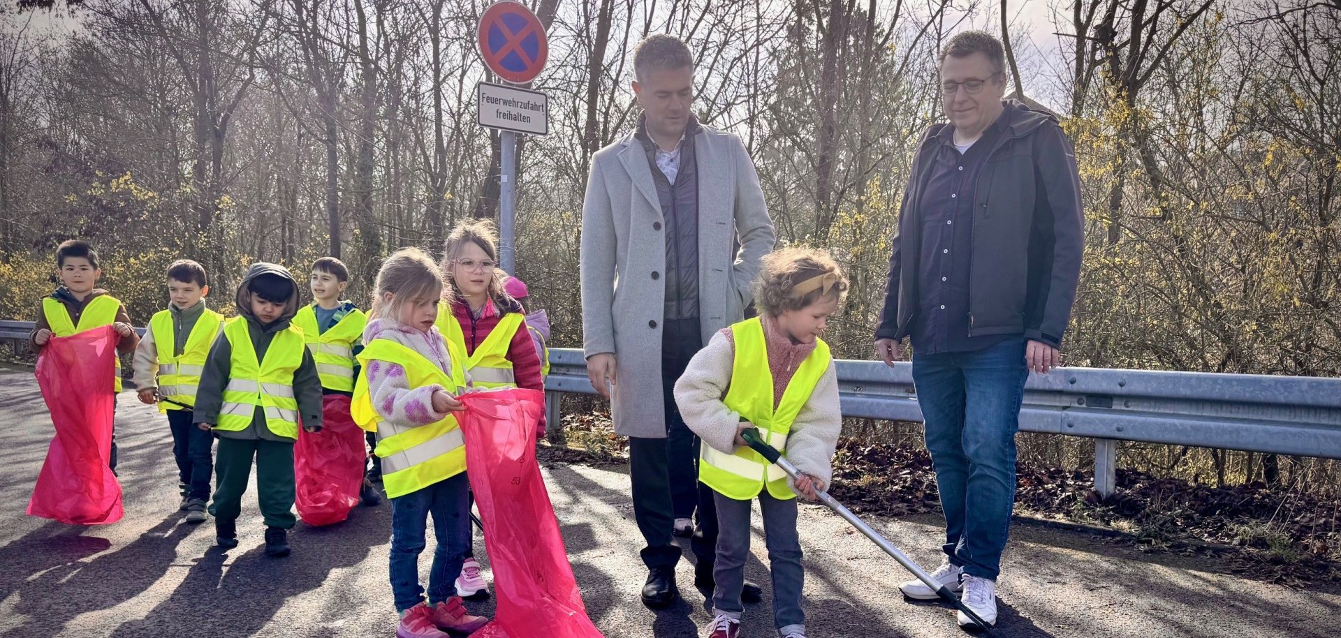 Eine Gruppe Kita Kinder die Müllsammeln zu sehen ist auch Bürgermeister Steffen Jung und Markus Krebs vom Stadtmarketing