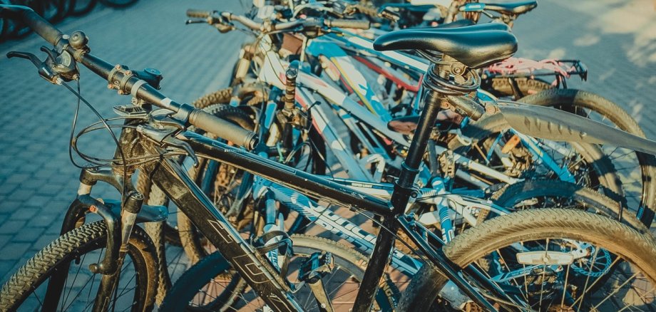 mehrere Fahrräder stehen in einer Reihe, es wurde über sie drüber hinweg fotografiert