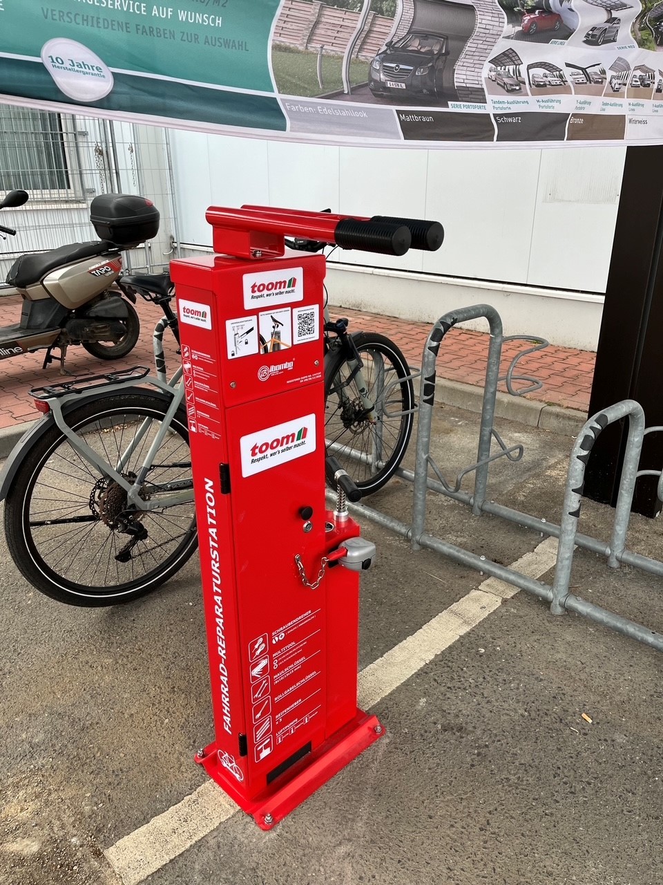 ein roter Kasten mit Notfallwerkzeug für Fahrräder vom Toom auf dem Fahrradparkplatz