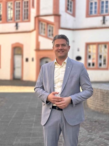 Bürgermeister Steffen Jung im grauen Anzug vor dem Fischmarkt in Alzey