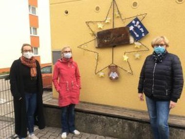 Gruppenfoto vor einem Stern, der an einer Hauswand hängt