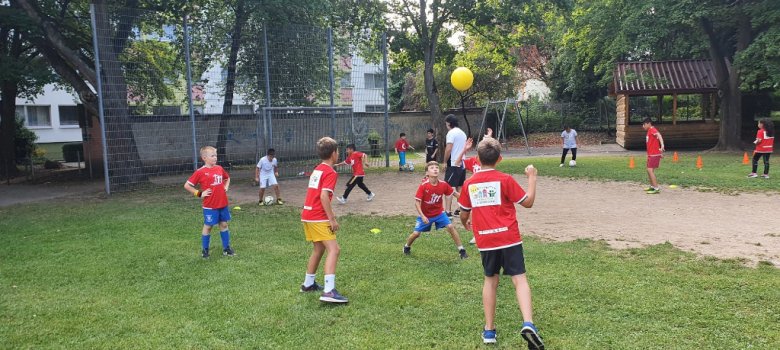 Mehrere Kinder spielen zusammen Fußball
